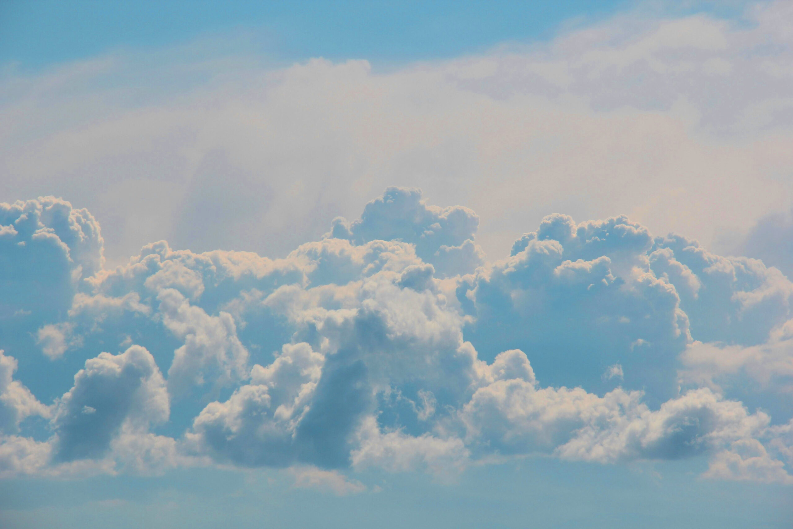Photo of billowing white clouds in a blue sky.